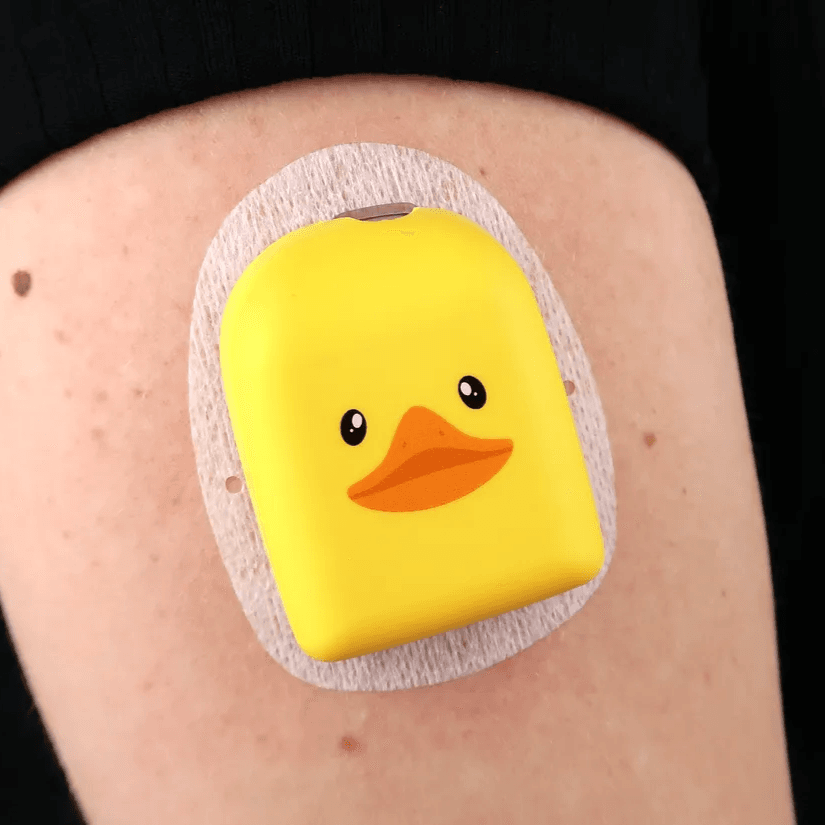 Husă Omnipod Duckie galben purtată pe braț